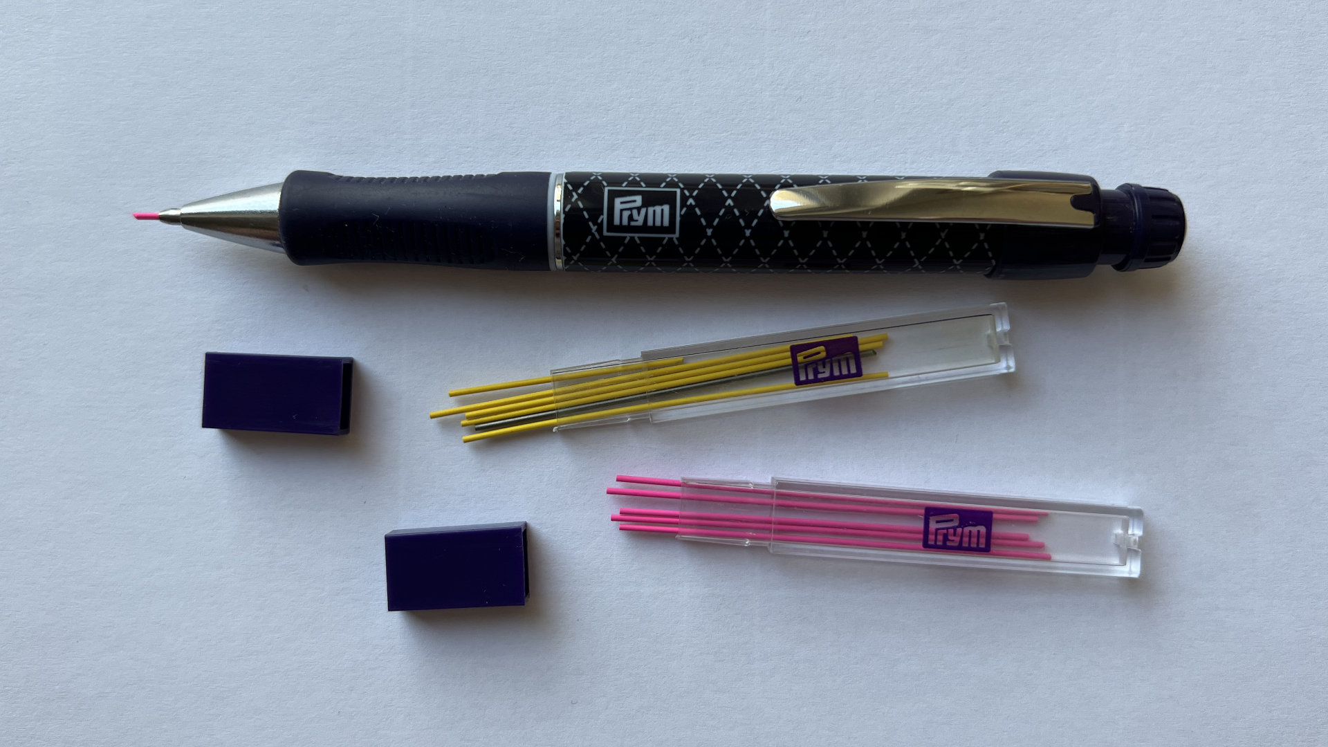 Prym pen and two clear cases containing yellow and pink leads.