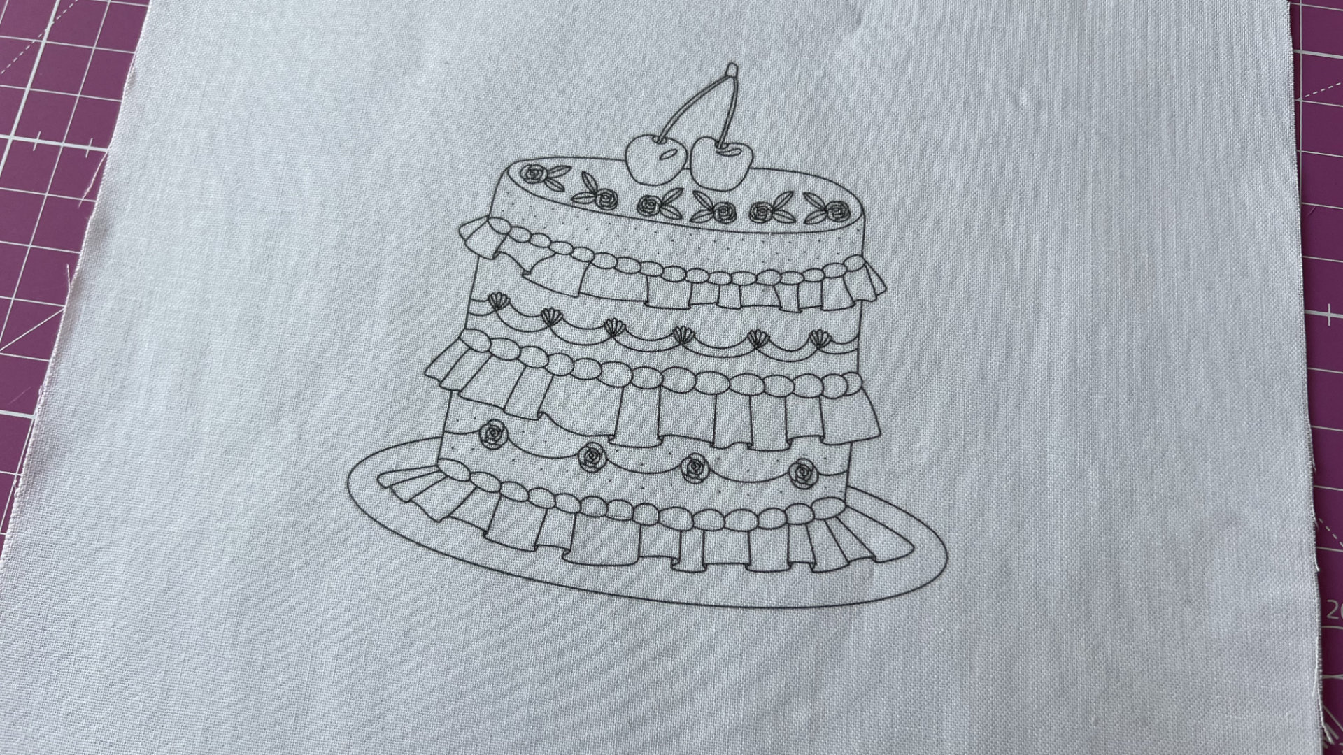 Printed design of a multi-tier cake with cherries on top and decorative ruffle borders on a plate.