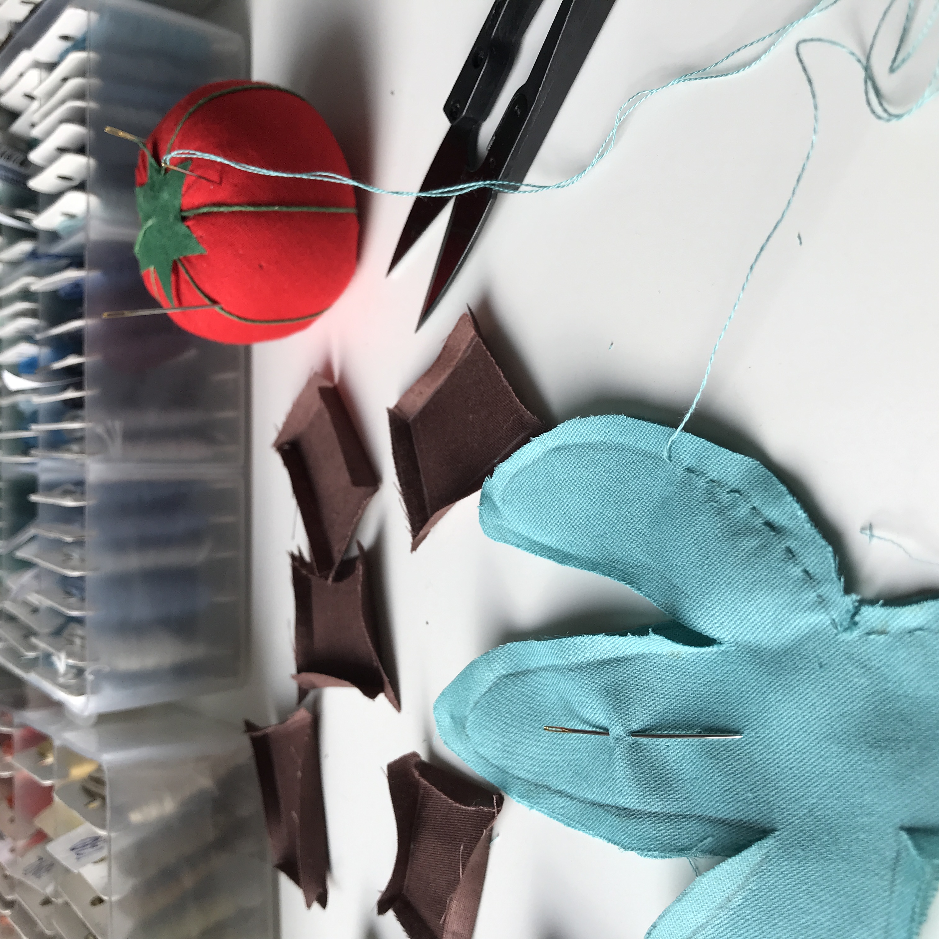 parts of the cactus pattern cut out of fabric and sewed together with running stitch